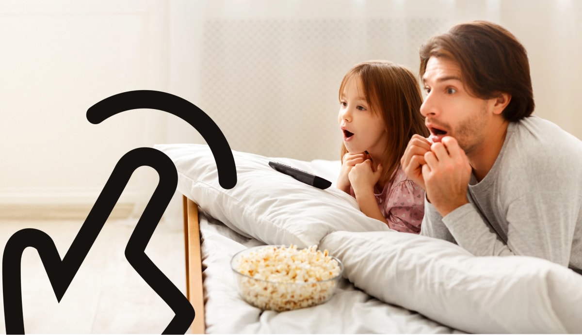 Father and daughter watching movies and eating popcorn